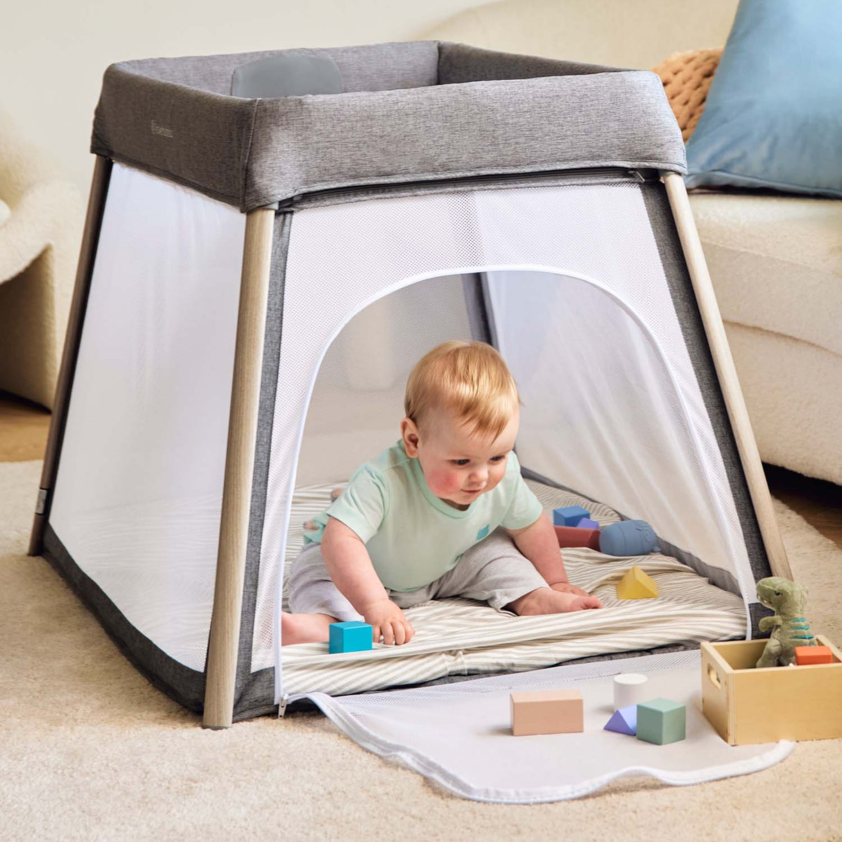 Baby sitting with toys inside the Ickle Bubba Scout 2-in-1 Travel Cot and Playpen