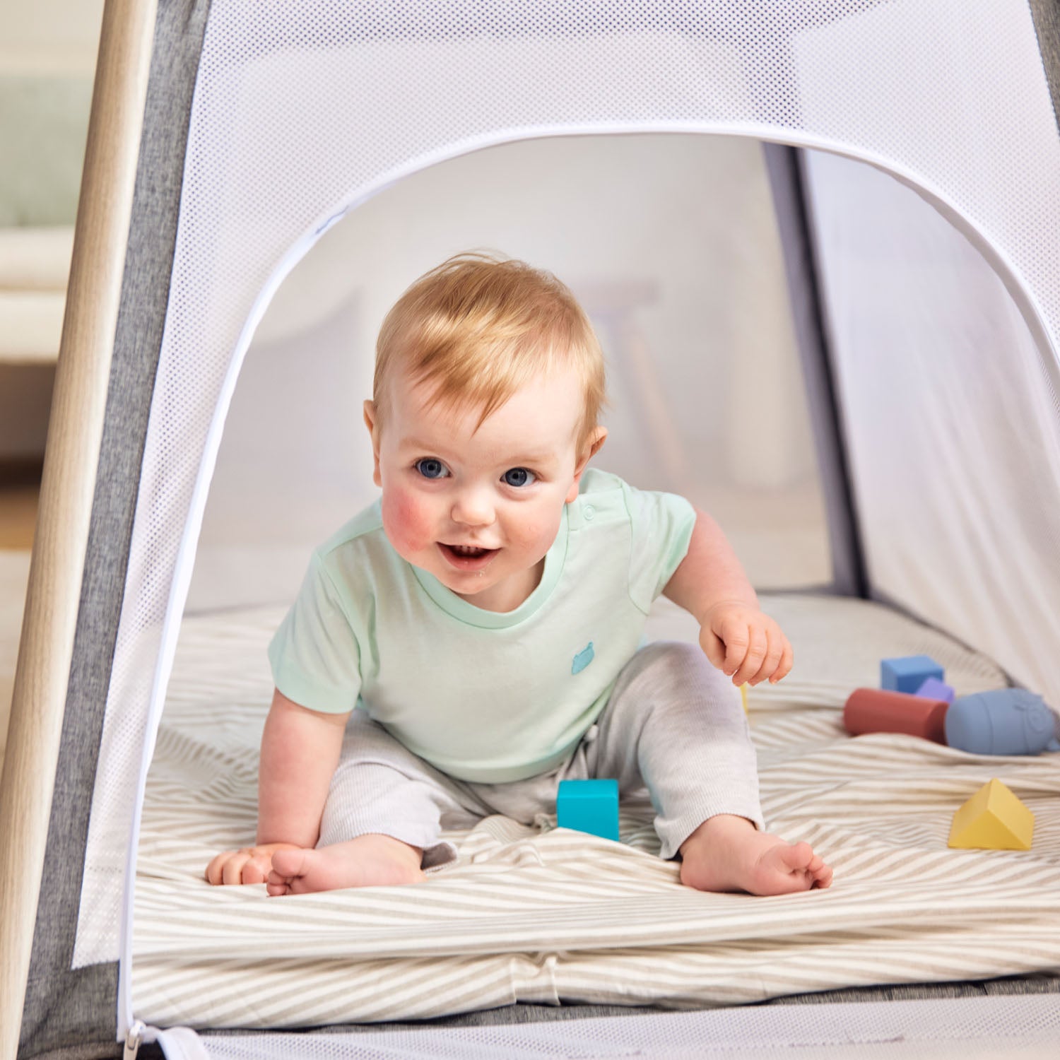 a baby having fun playing inside the Ickle Bubba Scout 2-in-1 Travel Cot and Playpen