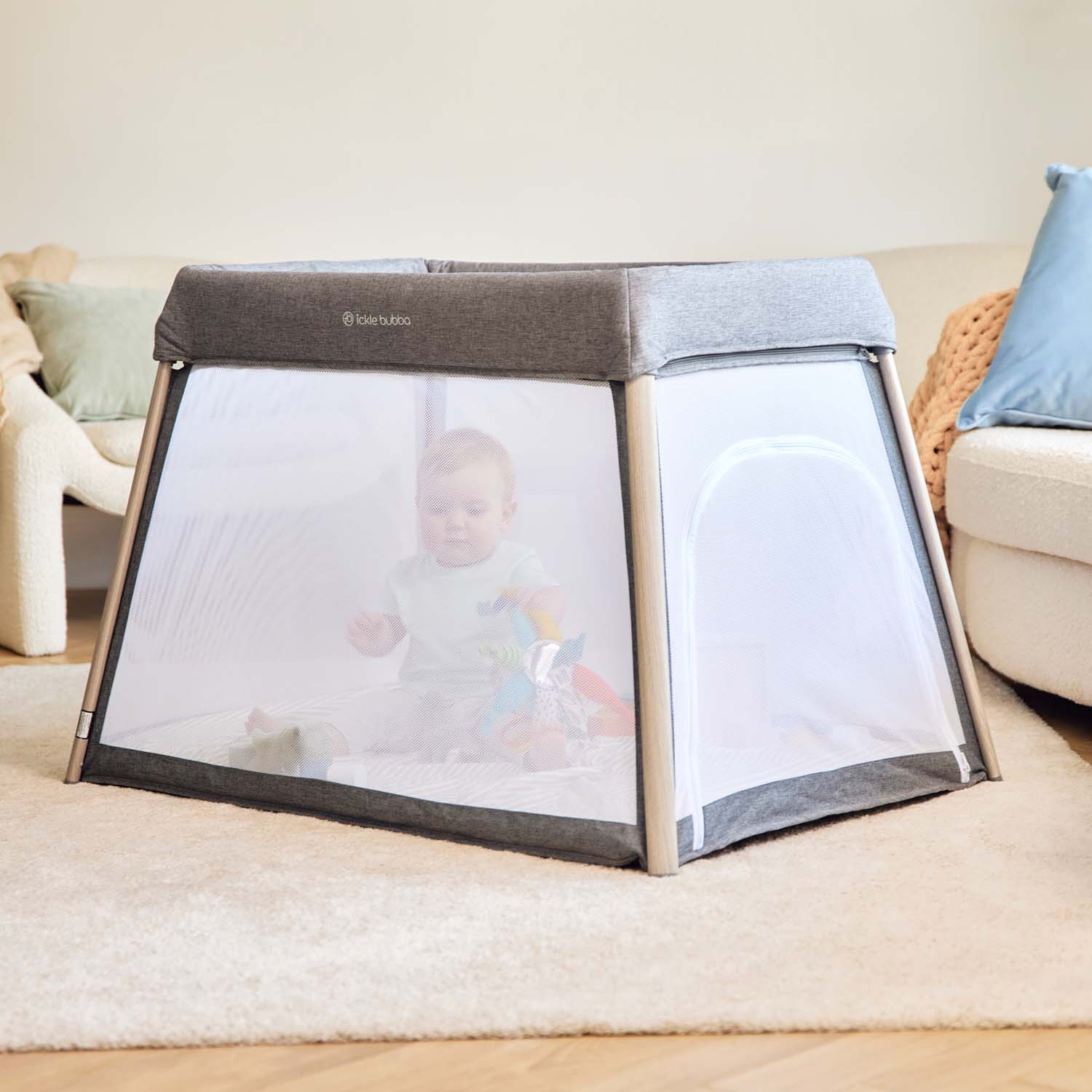 baby playing with toys inside the Ickle Bubba Scout 2-in-1 Travel Cot and Playpen