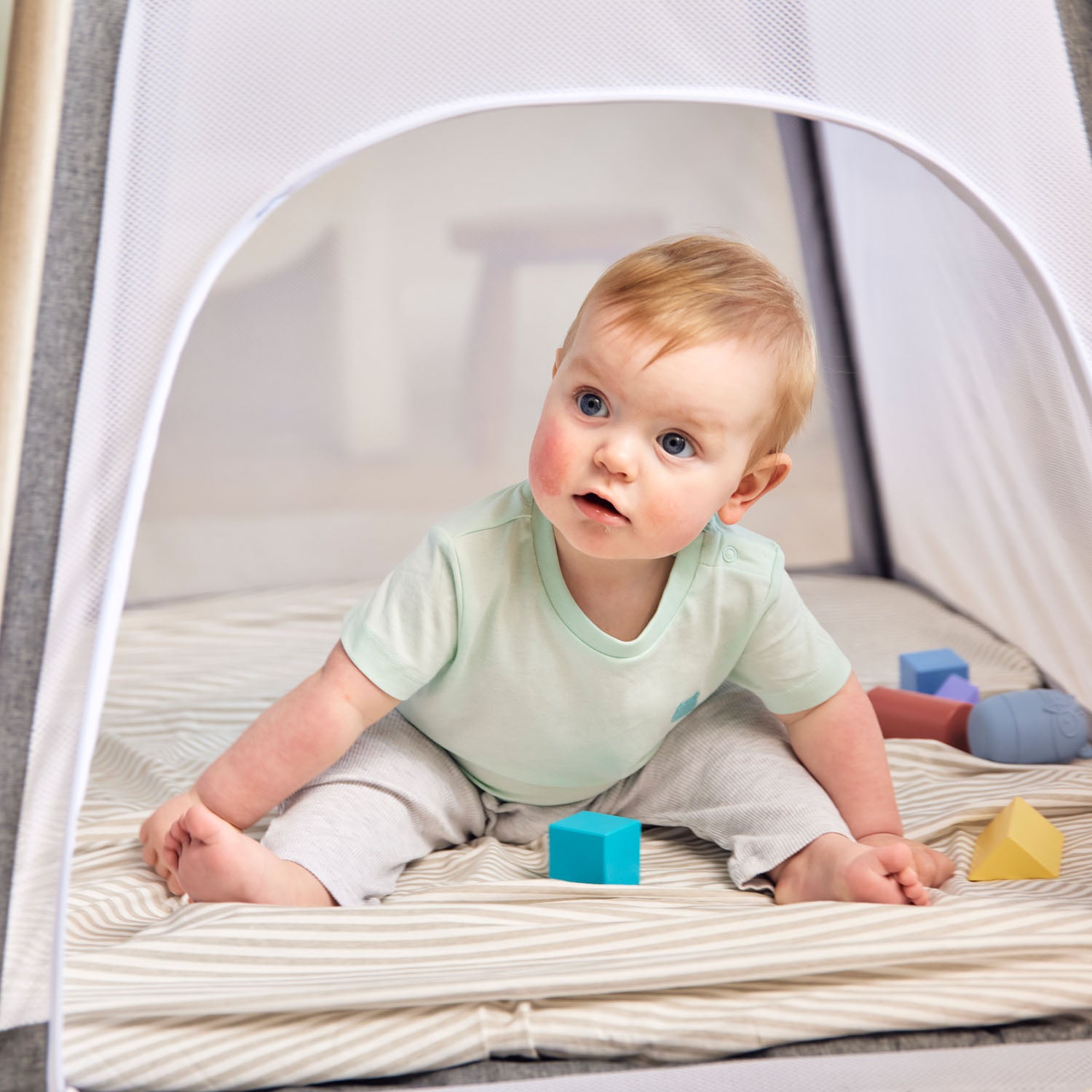 a baby having fun playing inside the Ickle Bubba Scout 3-in-1 Travel Crib, Cot and Playpen