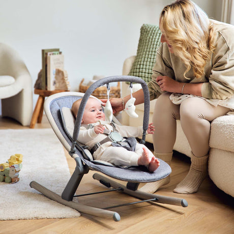 Baby looking at the hanging toys while sitting in Ickle Bubba Stella Rocker