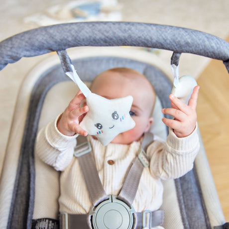 Baby playing with the two hanging sensory toys included in Ickle Bubba Stella Rocker