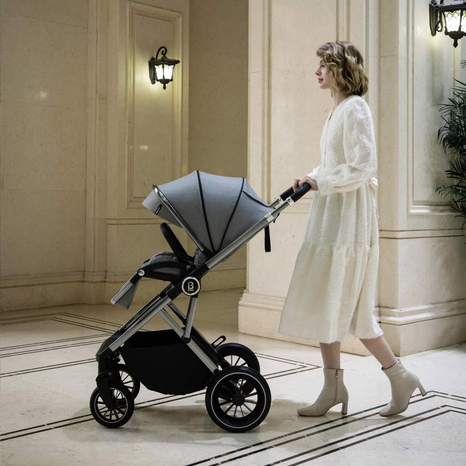 a woman pushing a Babymore Chia with seat unit in Pearl Grey colour