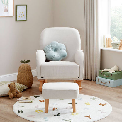 A straight-on front shot of Babymore Freya Nursing Chair with Footstool Set in Cream colour in a corner of a nursery room with a window at the right side.