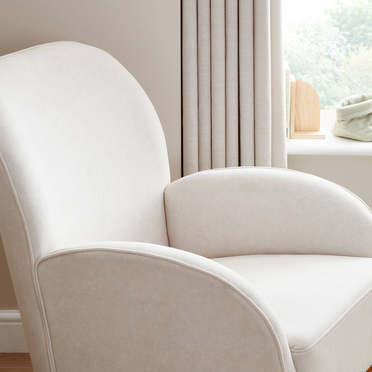A close-up macro shot of the Babymore Freya Nursing Chair showing its curved ergonomic design and supportive armrests in a nursery room.
