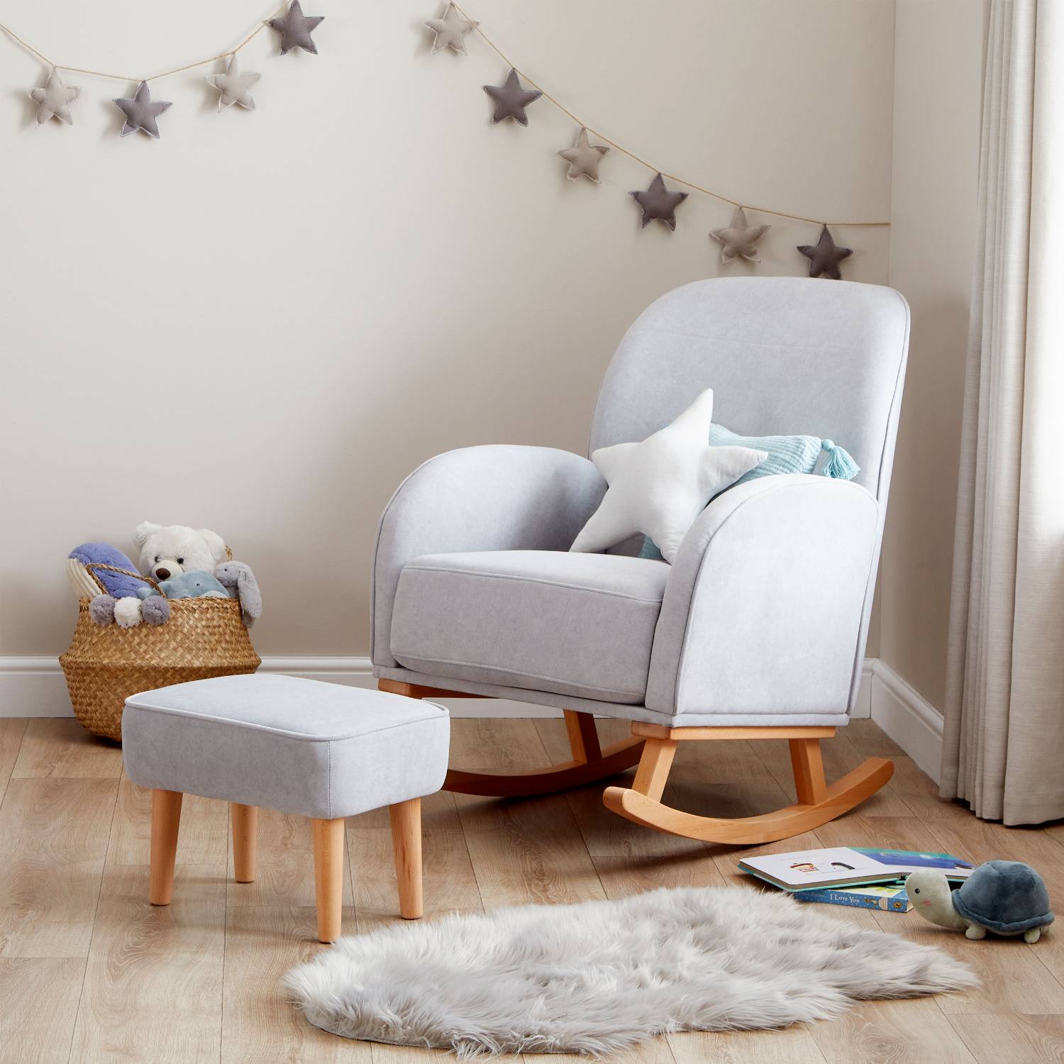 An angled shot of Babymore Freya Nursing Chair with Stool Set in Grey colour in a corner of a nursery room with plush stars wall hanging decor.