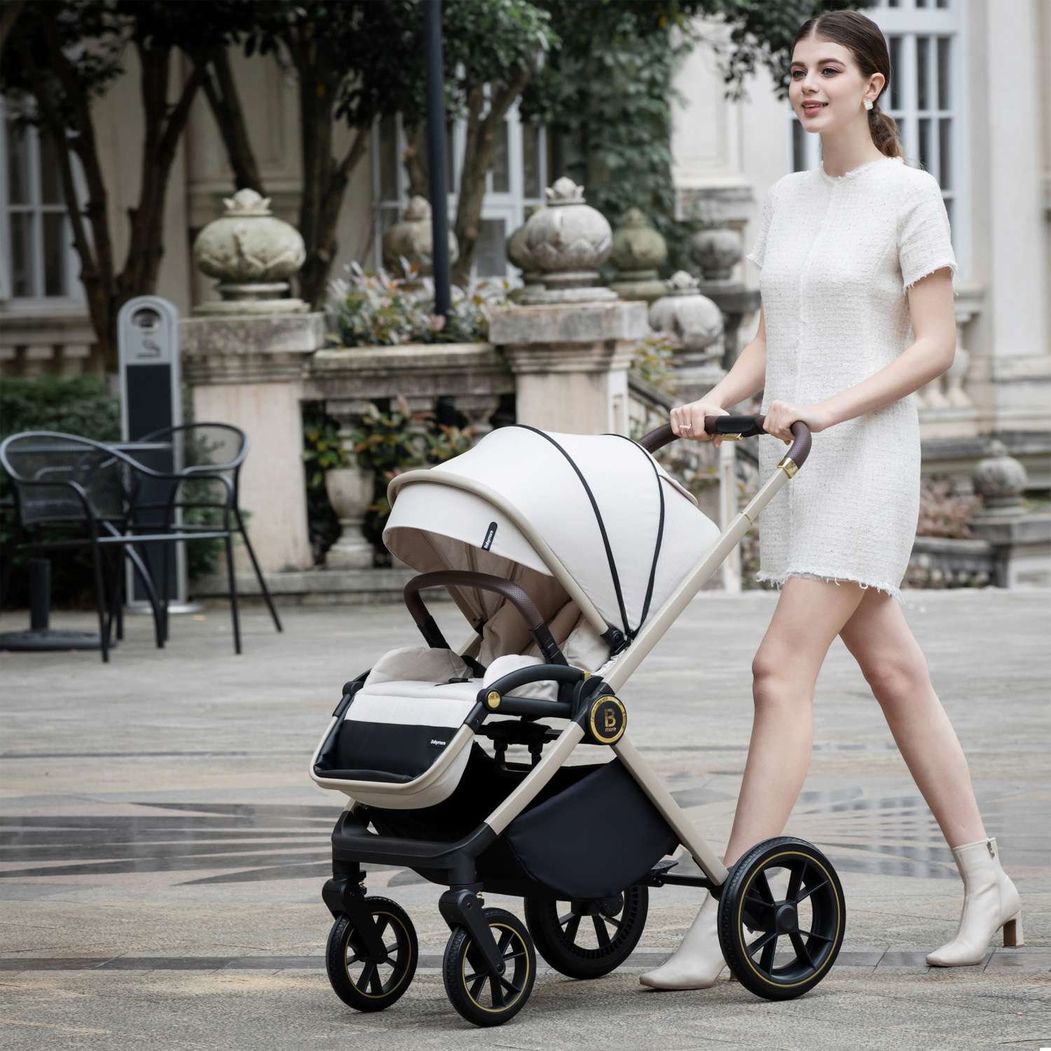 a woman walking with a Babymore Kai with seat unit in Sandstone colour