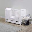 A white Ickle Bubba Coleby Mini 2-in-1 Cot Bed with Under Drawer in a nursery room