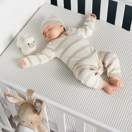 a baby sleeping peacefully on a cot bed