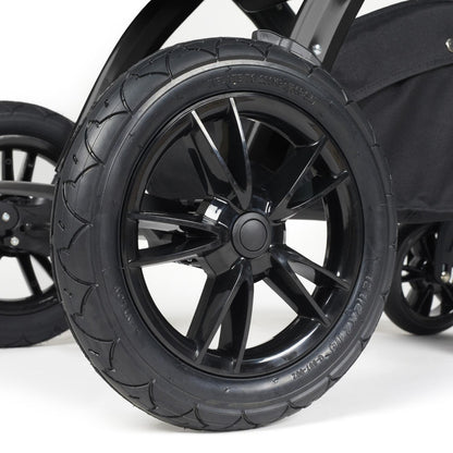 Close-up shot of all-terrain wheels in Ickle Bubba Stomp Luxe Pushchair in Midnight black colour