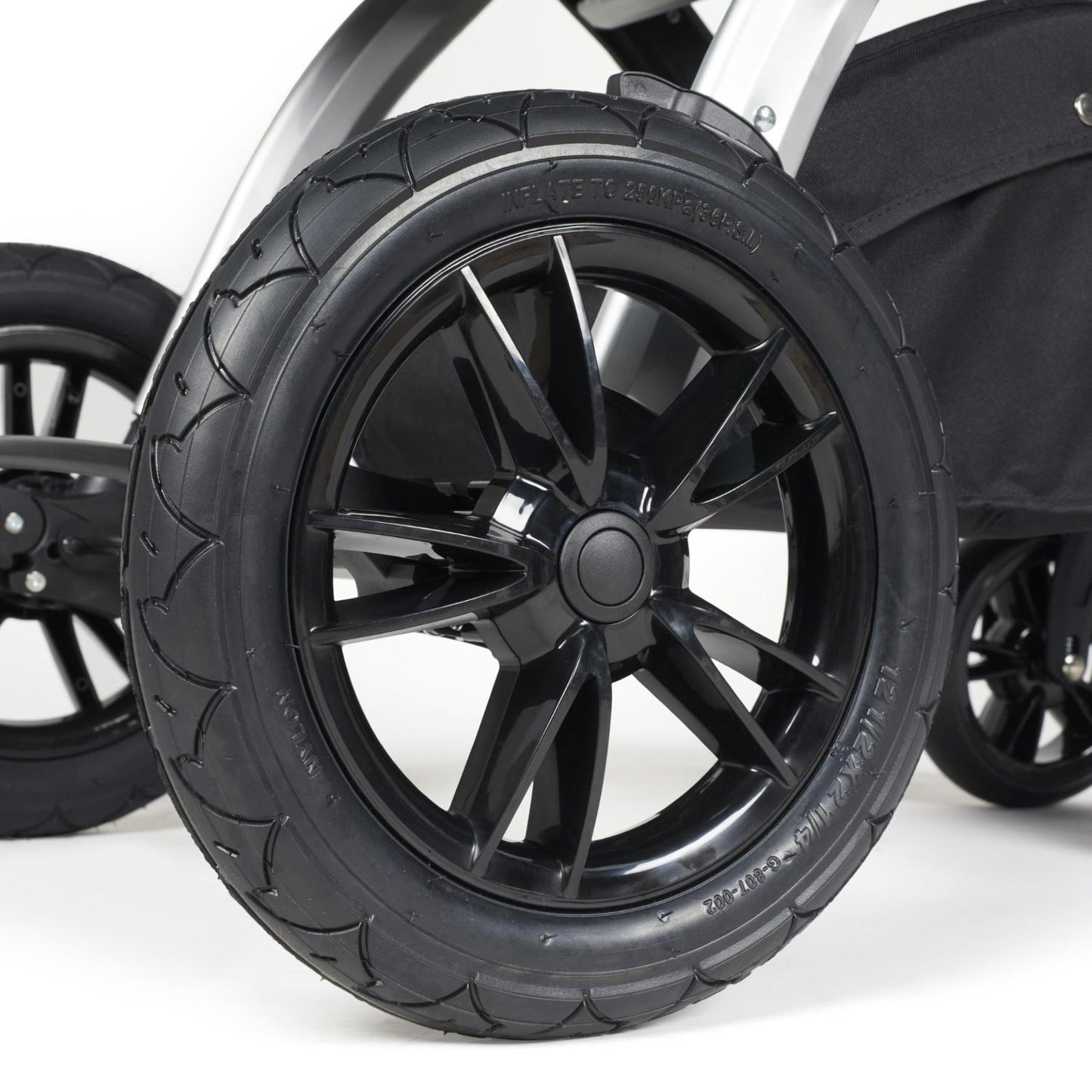 Close-up shot of all-terrain wheels in Ickle Bubba Stomp Luxe Pushchair in Desert beige colour with silver chassis and tan handle
