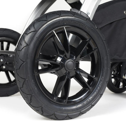 Close-up shot of all-terrain wheels in Ickle Bubba Stomp Luxe Pushchair in Midnight black colour with silver chassis and tan handle