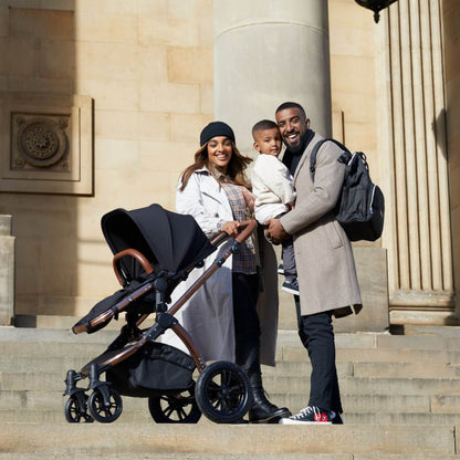 Happy family of 3 with their Ickle Bubba Stomp Luxe All-in-One Travel System in Midnight colour