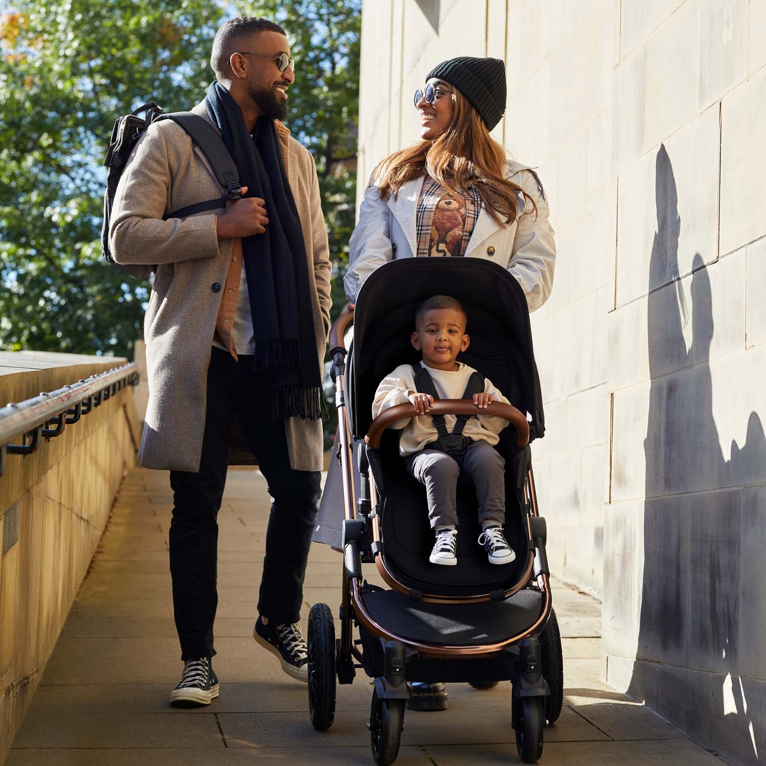 A couple with their son riding an Ickle Bubba Stomp Luxe Pushchair