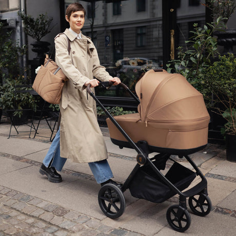 Woman pushing a Venicci Claro Pram in Caramel brown colour