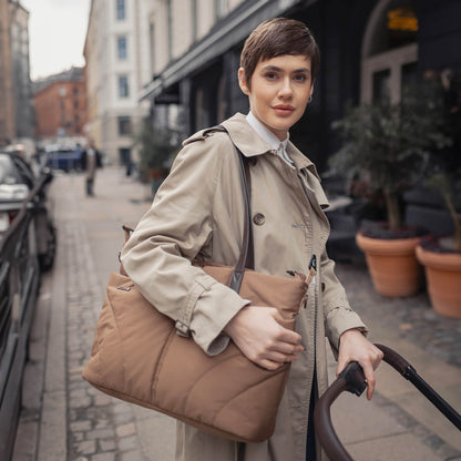 Woman carrying the stylish Venicci Claro mommy bag in Caramel colour
