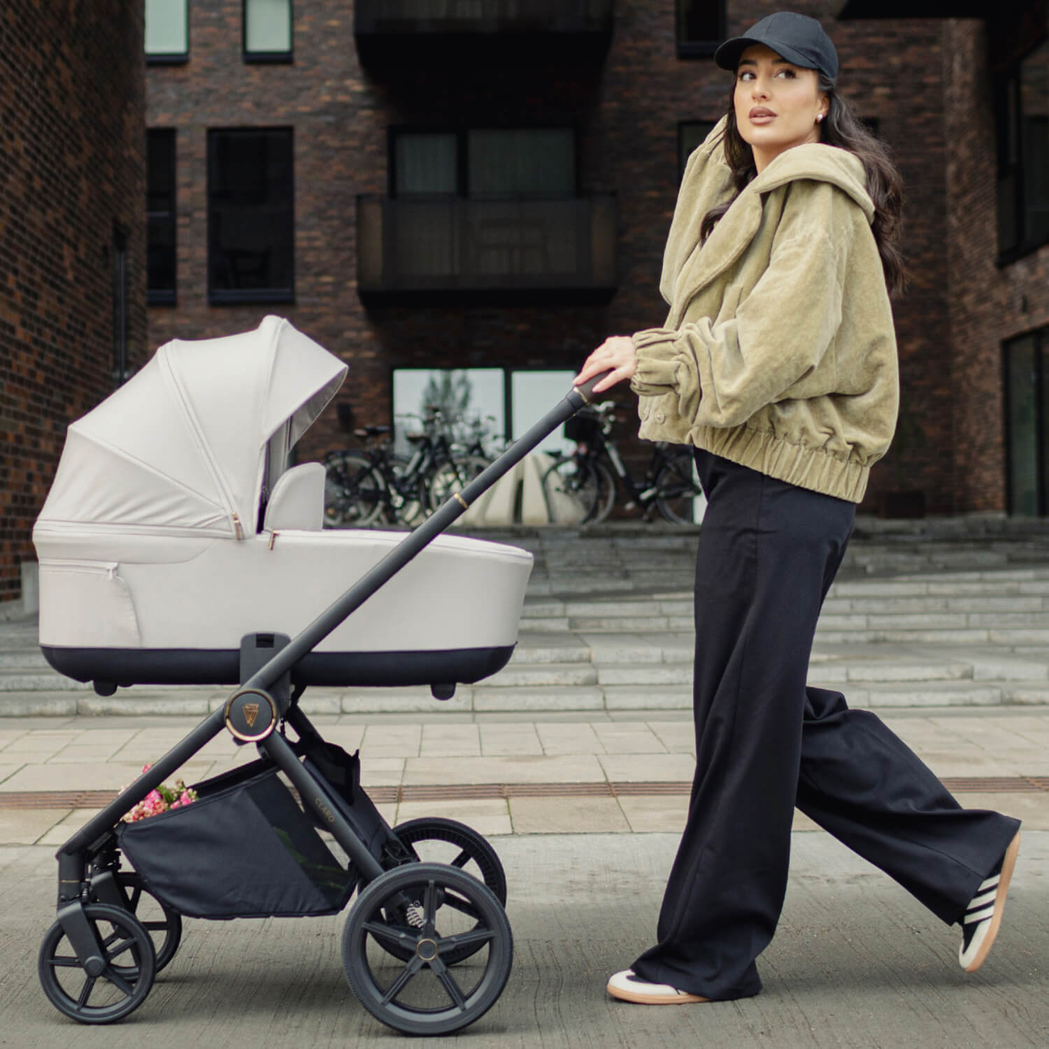 A mother walking and pushing a Vanilla Venicci Claro 2-in-1 Pram