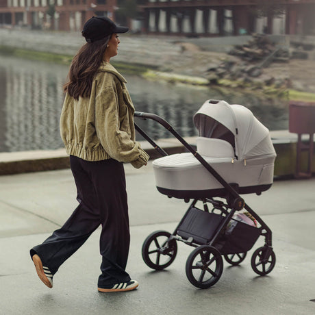 A woman with Woman pushing a Venicci Claro Pram in Vanilla white colour