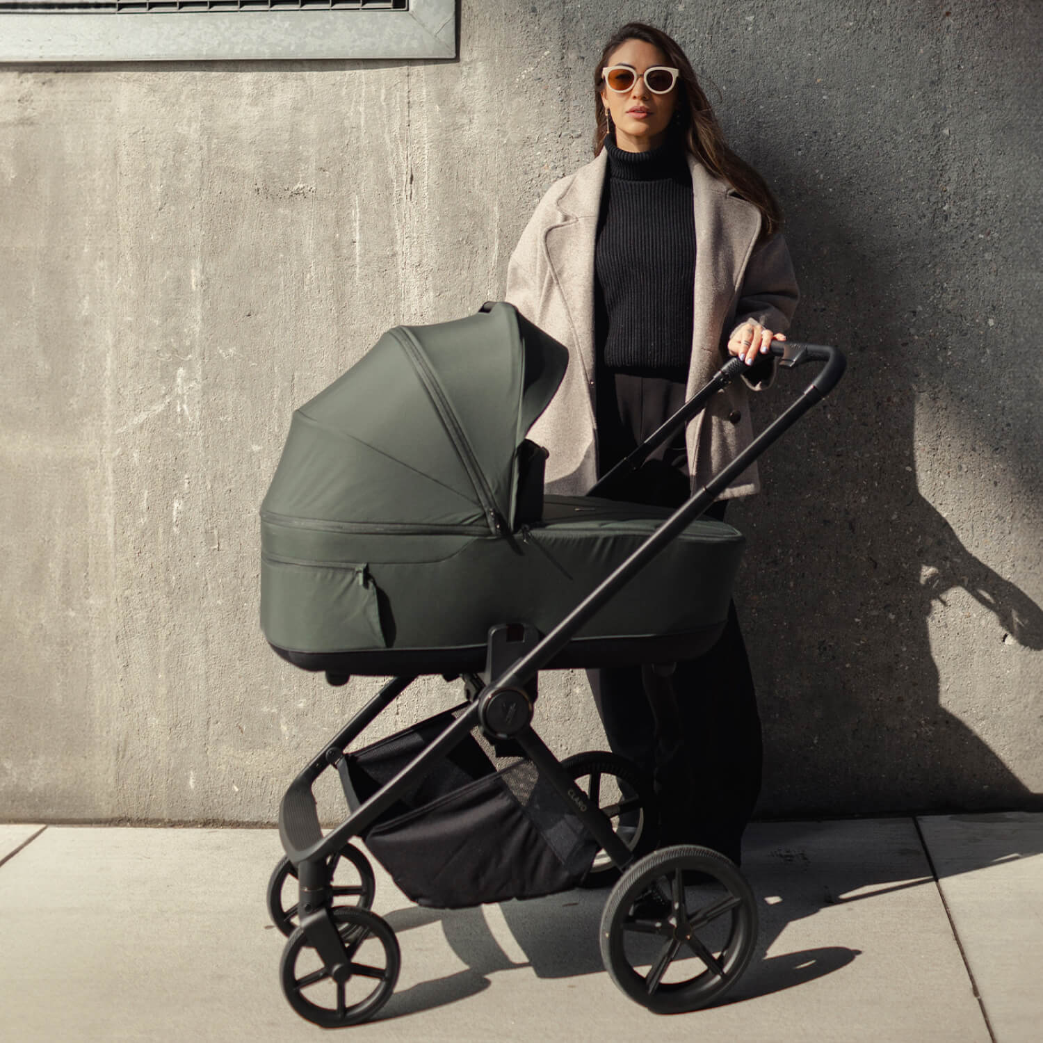 A woman with a Venicci Claro Pushchair in Forest green colour