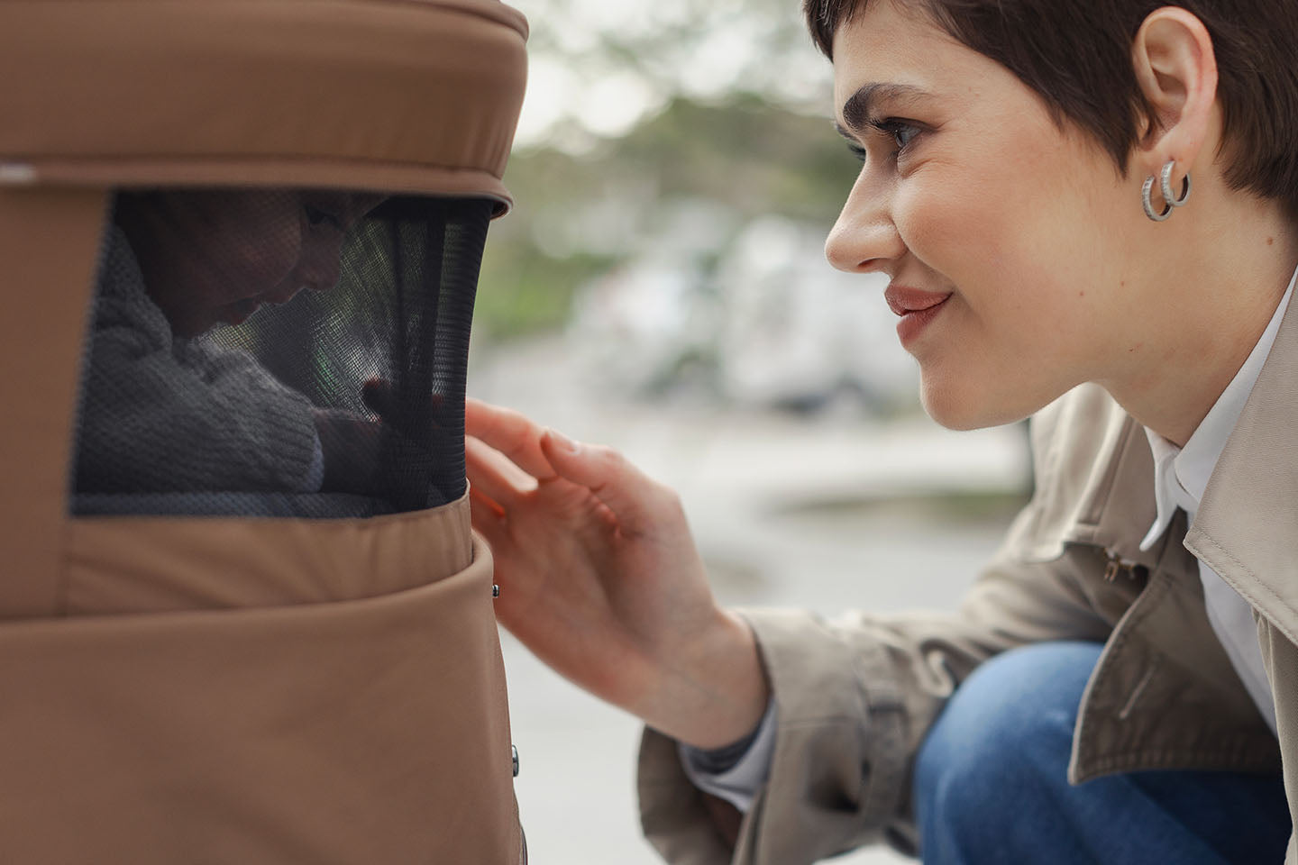 A baby peeking through the panoramic ventilation in the Venicci Claro Carrycot