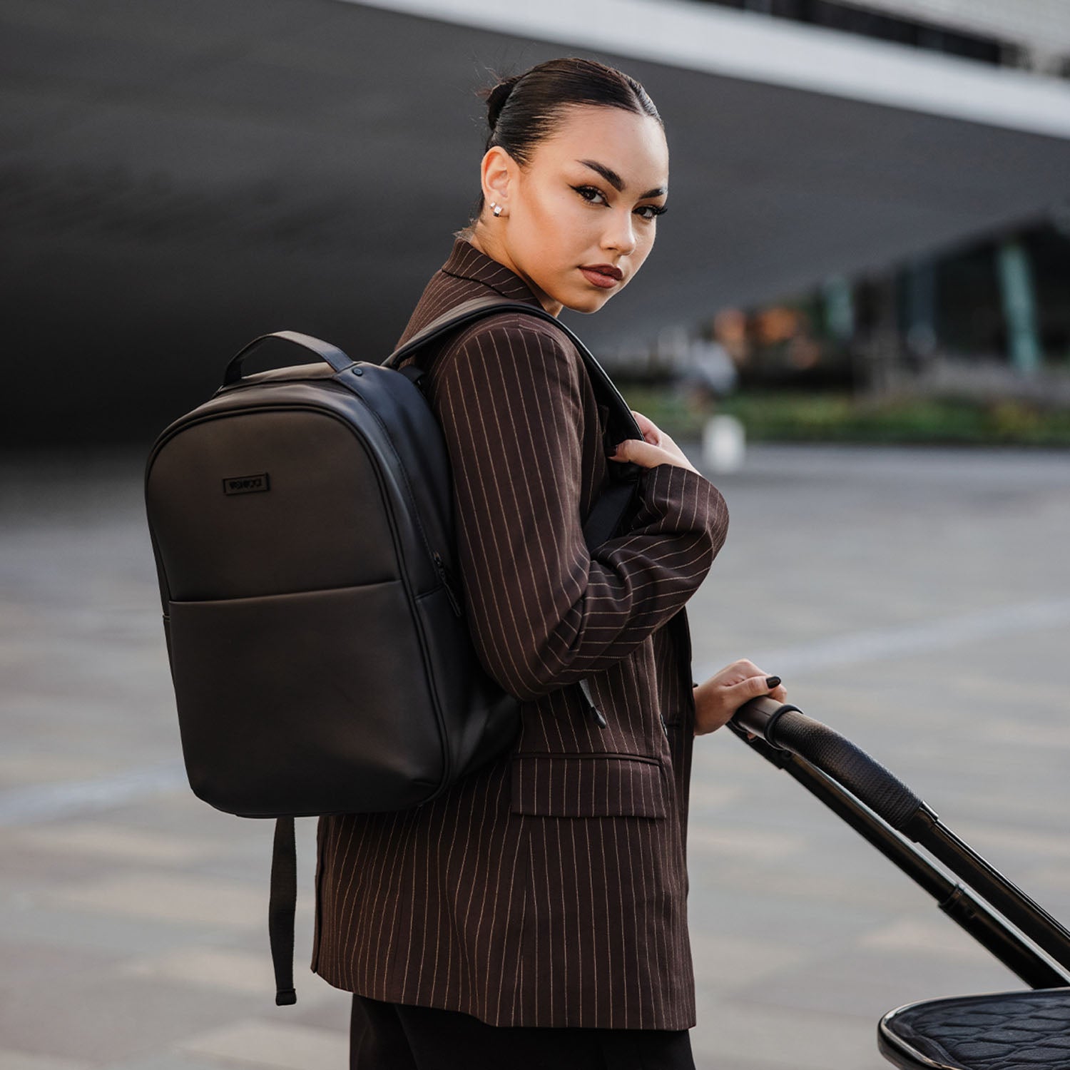 Woman carrying the Venicci Tinum Edge SE Backpack in coordinating Raven black colour