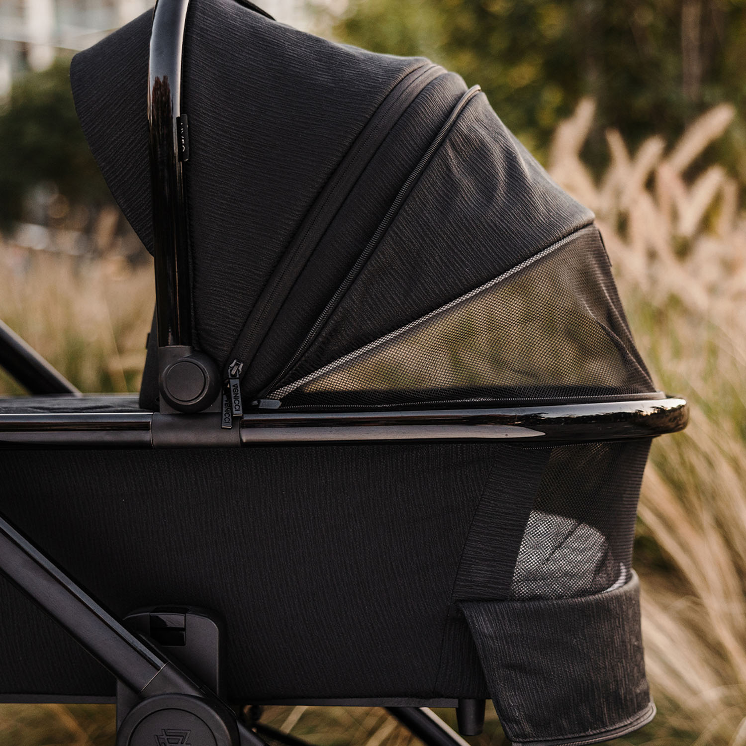 a Venicci Tinum Edge SE Raven Carrycot with opened panoramic ventilation panel