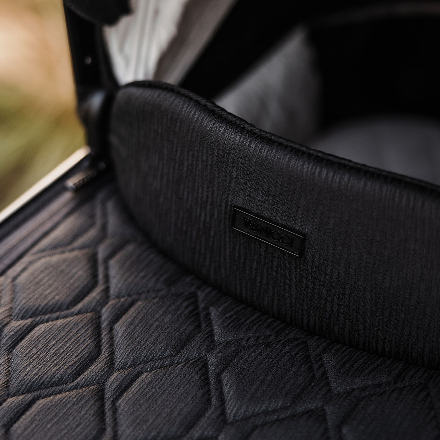 Minimalist logo detail in Venicci Tinum Edge SE Carrycot