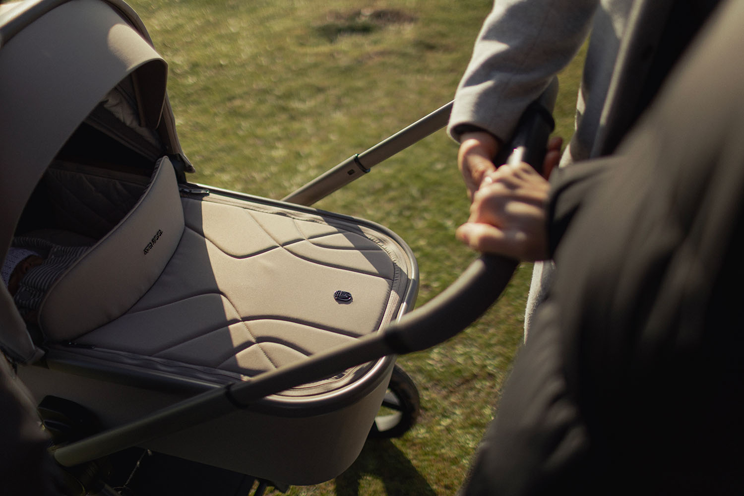 A couple holding the Venicci Upline 2 Pram Pushchair in Taupe colour